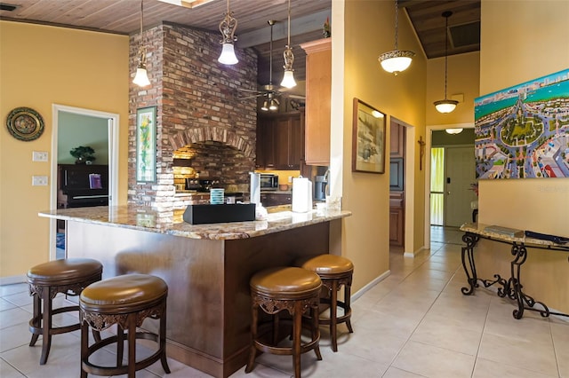 kitchen with light stone countertops, wooden ceiling, pendant lighting, a kitchen bar, and kitchen peninsula