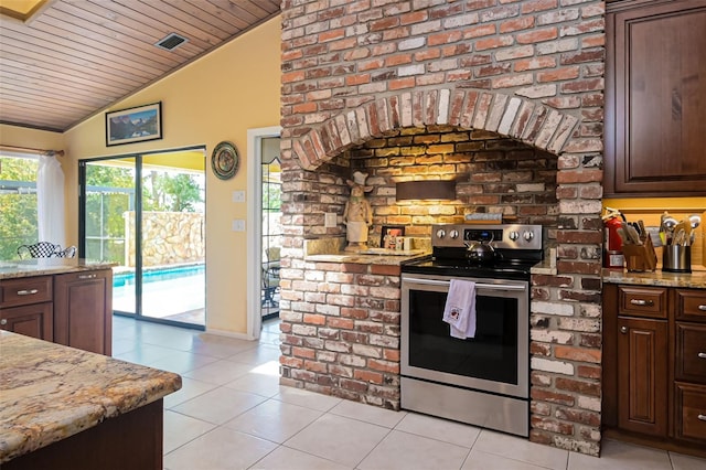 kitchen with vaulted ceiling, stainless steel range with electric cooktop, light tile patterned floors, and dark brown cabinetry