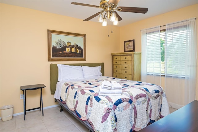 tiled bedroom with baseboards and a ceiling fan