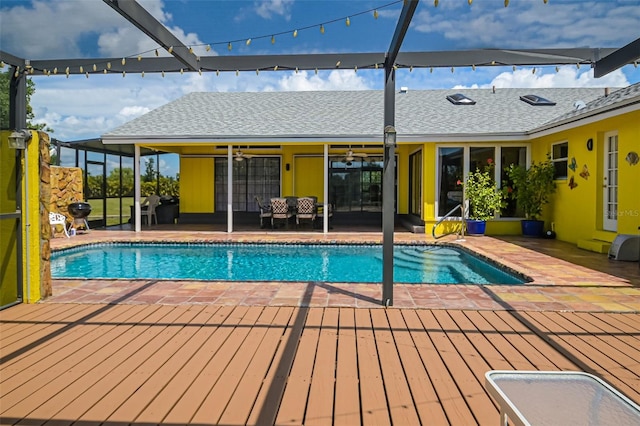 view of pool with ceiling fan, a wooden deck, and a patio