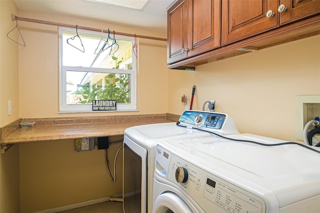 laundry room with washing machine and clothes dryer and cabinets