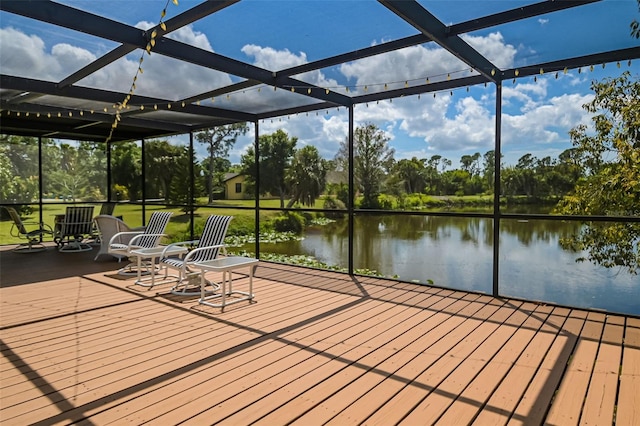 exterior space with glass enclosure and a water view