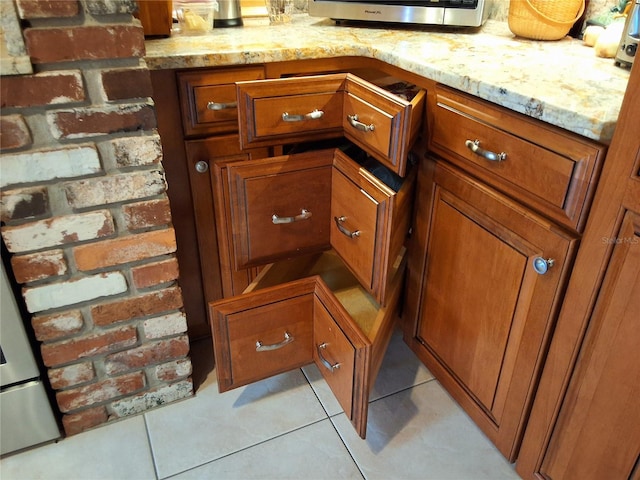 interior details with light stone counters and brown cabinets