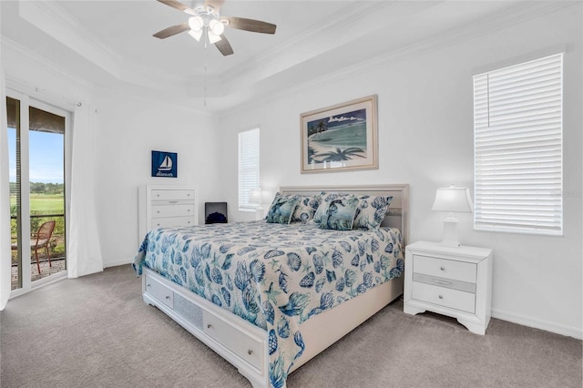 carpeted bedroom with access to outside, ornamental molding, a raised ceiling, and a ceiling fan