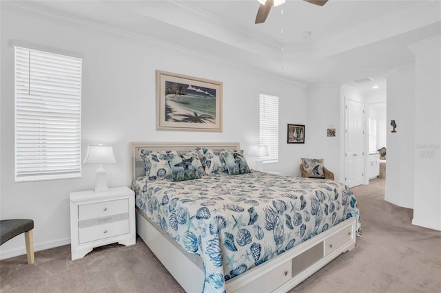 bedroom featuring carpet floors, baseboards, ornamental molding, and a tray ceiling