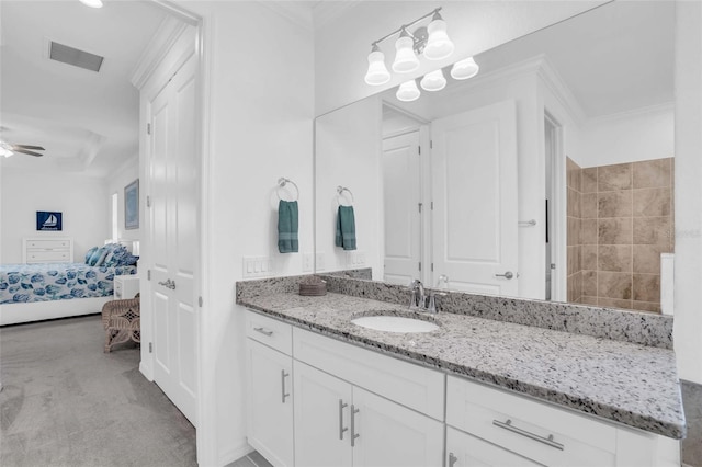 ensuite bathroom with ensuite bathroom, a ceiling fan, vanity, visible vents, and crown molding