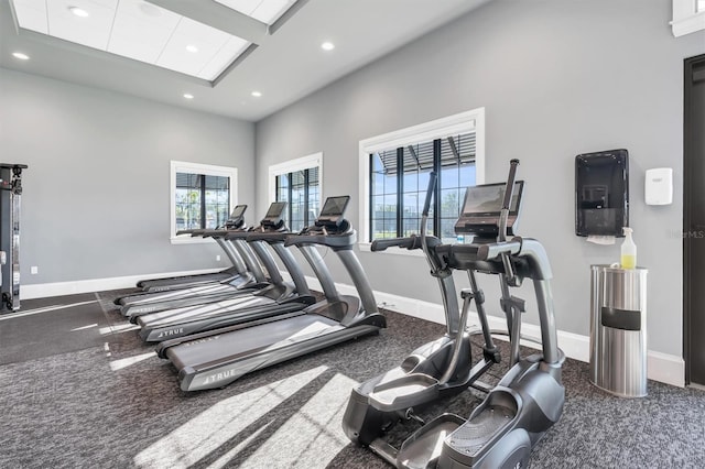 workout area featuring recessed lighting, a high ceiling, and baseboards