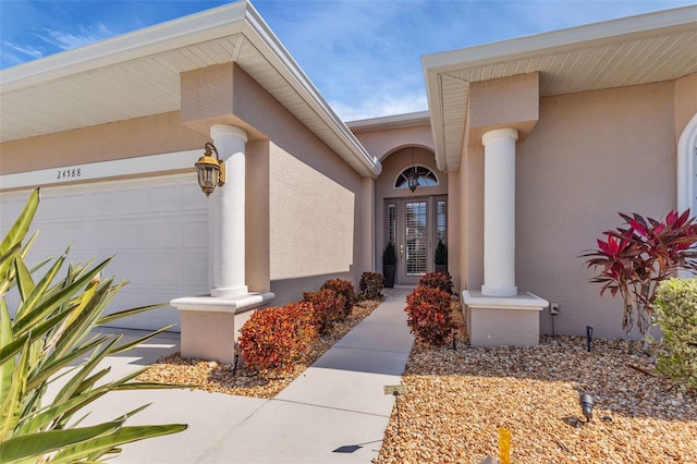 24588 Buckingham Way, Port Charlotte, FL 33980 - doorway to property featuring stucco siding and an attached garage
