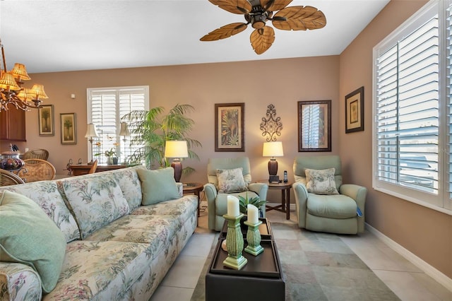 tiled living room featuring ceiling fan with notable chandelier