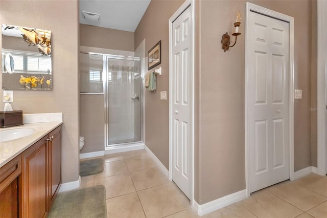 bathroom featuring vanity, toilet, tile patterned flooring, and a shower with door