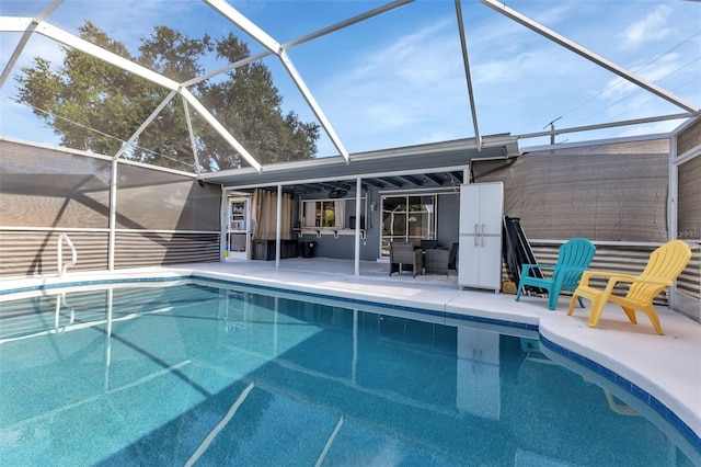 view of swimming pool featuring glass enclosure and a patio area