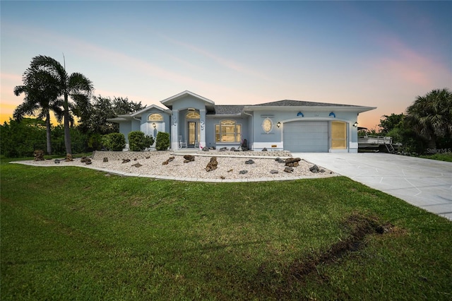 ranch-style house with a garage and a yard