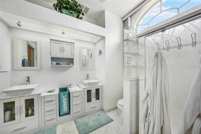 bathroom with a shower, toilet, and vanity