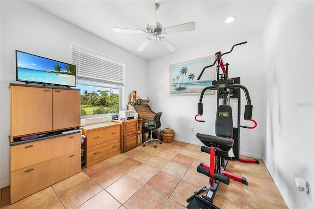 exercise room with light tile patterned floors and ceiling fan