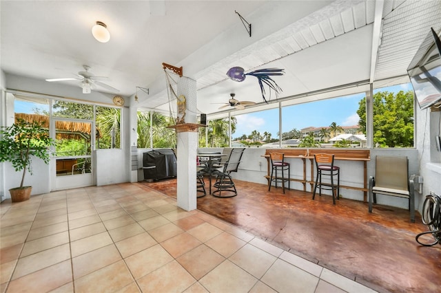 unfurnished sunroom with ceiling fan