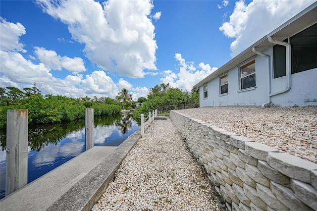 exterior space with a water view and a dock