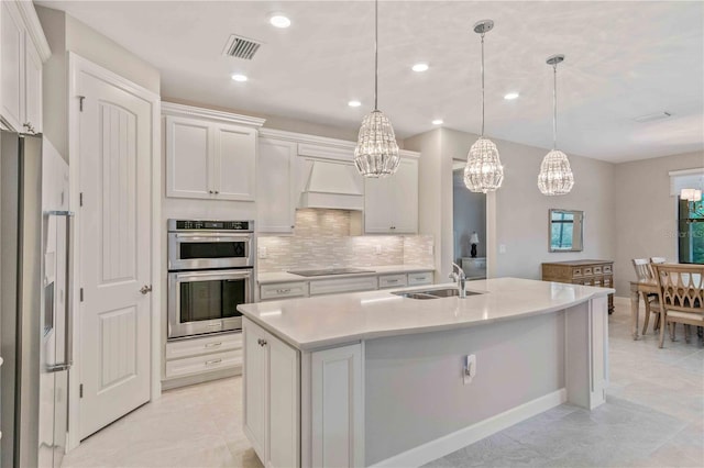 kitchen featuring stainless steel appliances, premium range hood, a sink, light countertops, and decorative backsplash