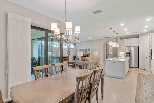 dining space featuring arched walkways, recessed lighting, visible vents, and a notable chandelier