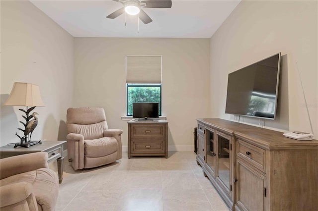 living room featuring ceiling fan, baseboards, and light tile patterned floors