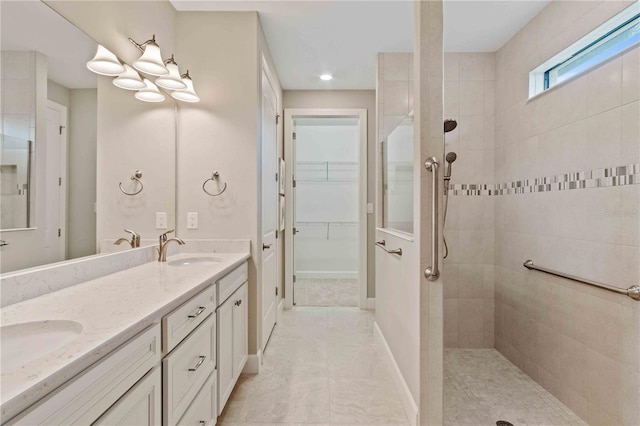 full bath featuring a sink, baseboards, a walk in closet, double vanity, and walk in shower