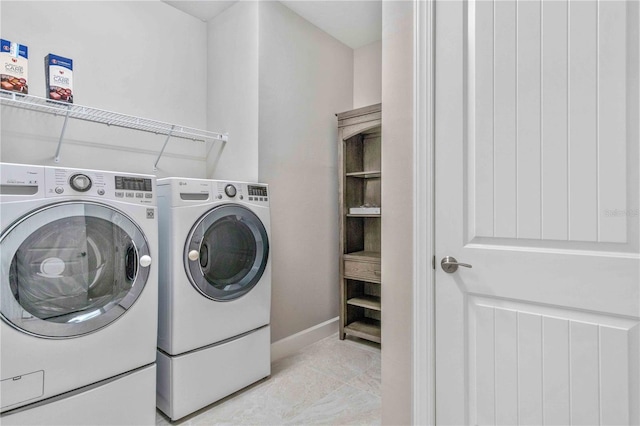 laundry room featuring laundry area, baseboards, and washing machine and clothes dryer