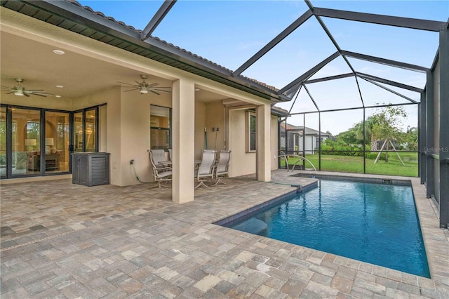 pool featuring a patio, glass enclosure, and a ceiling fan