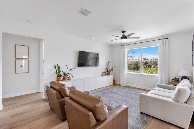 living room with light hardwood / wood-style flooring and ceiling fan