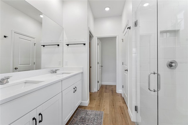 bathroom featuring vanity, an enclosed shower, and hardwood / wood-style flooring