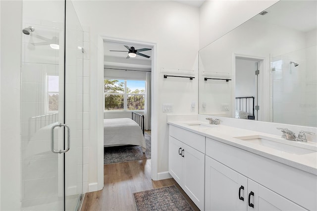 bathroom with vanity, wood-type flooring, walk in shower, ceiling fan, and radiator heating unit