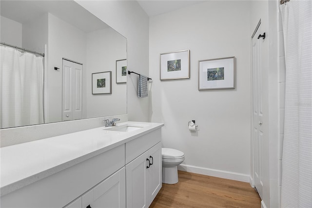 bathroom featuring vanity, toilet, and hardwood / wood-style floors