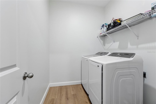 laundry room featuring light hardwood / wood-style floors and washing machine and clothes dryer