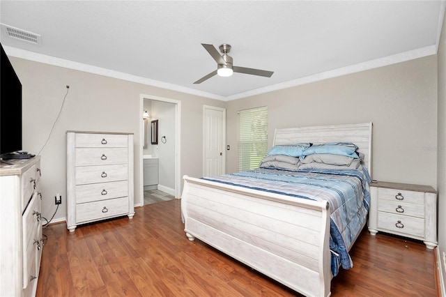 bedroom featuring dark wood-type flooring, ceiling fan, ornamental molding, and ensuite bath