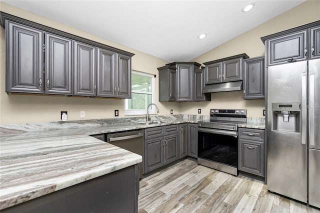 3159 Draper Ter, North Port, FL 34286 - kitchen featuring stainless steel appliances, under cabinet range hood, vaulted ceiling, light stone counters, and light wood-style floors