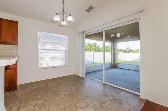 unfurnished dining area with lofted ceiling and an inviting chandelier