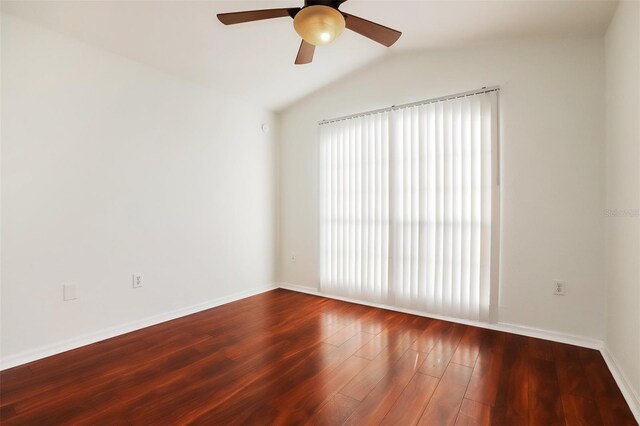 empty room with lofted ceiling, ceiling fan, and dark hardwood / wood-style flooring