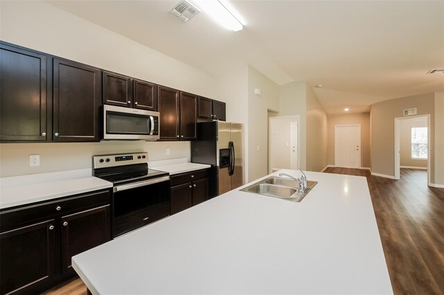 kitchen with appliances with stainless steel finishes, dark hardwood / wood-style floors, and sink