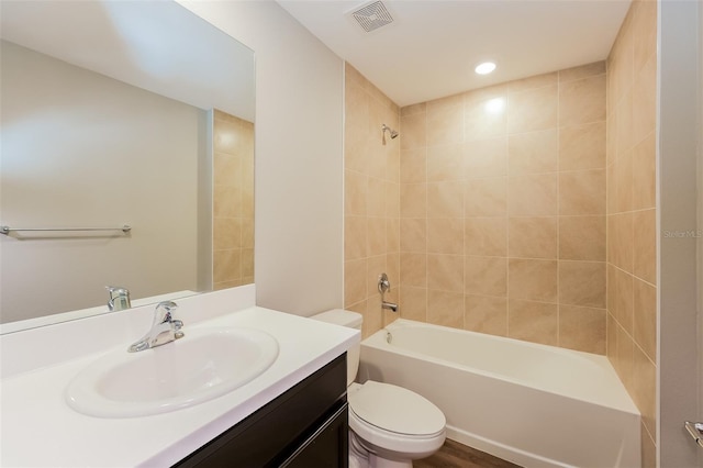 full bathroom with tiled shower / bath combo, vanity, and toilet