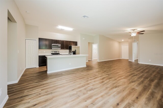 kitchen featuring a center island with sink, light hardwood / wood-style flooring, stainless steel appliances, and ceiling fan