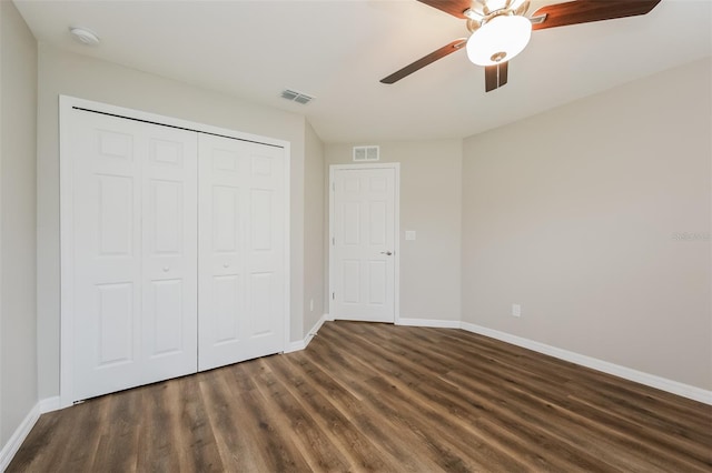 unfurnished bedroom with dark wood-type flooring, ceiling fan, and a closet