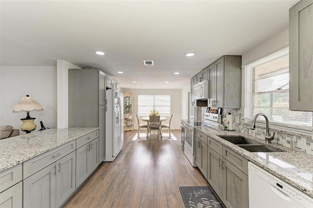 kitchen featuring a wealth of natural light, sink, white appliances, and hardwood / wood-style flooring