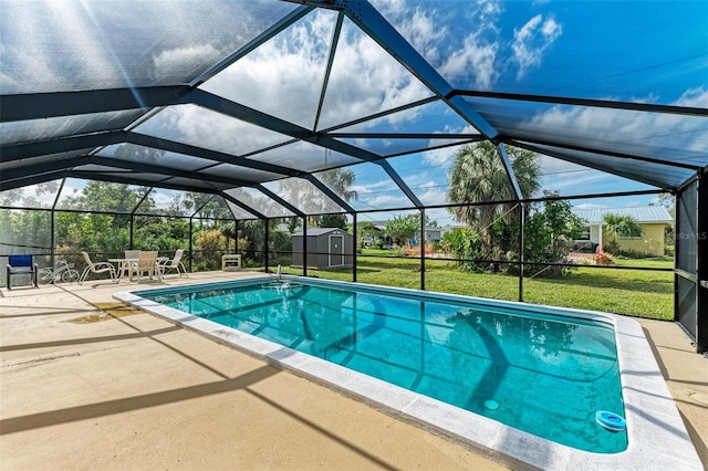 view of swimming pool with a patio, glass enclosure, a storage shed, and a lawn