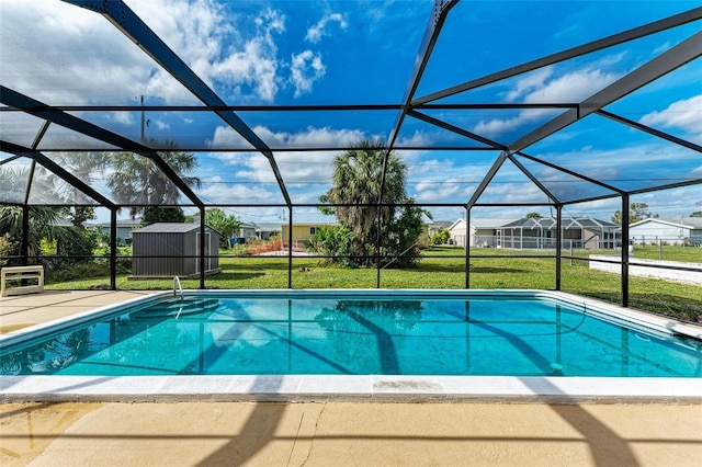 view of swimming pool with a patio area, a shed, a lanai, and a lawn