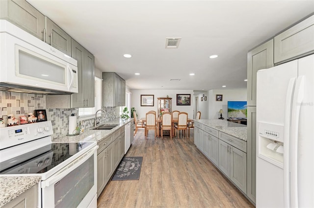 kitchen featuring gray cabinetry, dark hardwood / wood-style flooring, white appliances, and sink