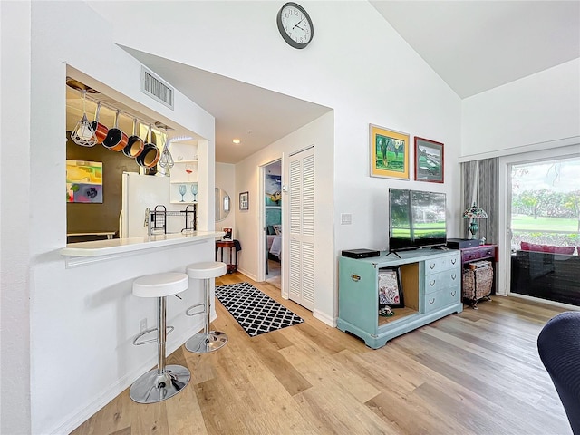 kitchen with lofted ceiling, white refrigerator, and light wood-type flooring