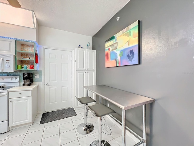 office with a textured ceiling and light tile patterned floors