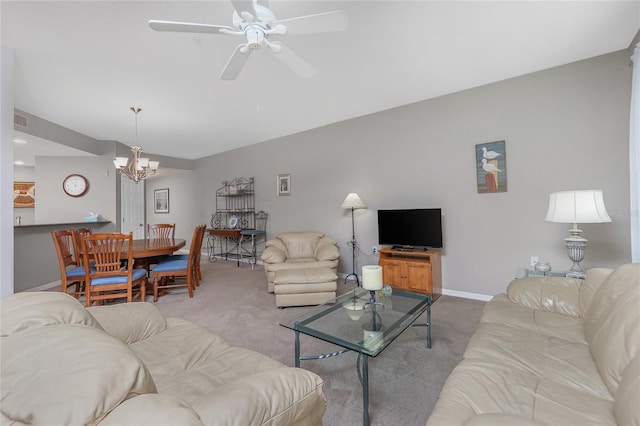 carpeted living room featuring ceiling fan with notable chandelier