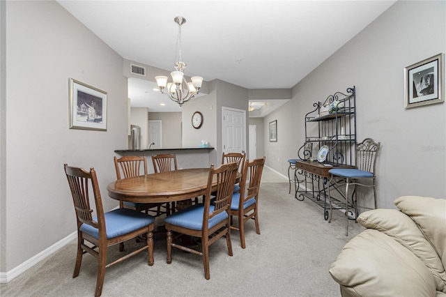 dining area featuring carpet flooring and a chandelier