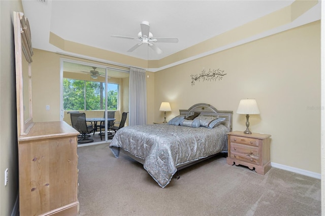 bedroom with a raised ceiling, ceiling fan, and carpet floors