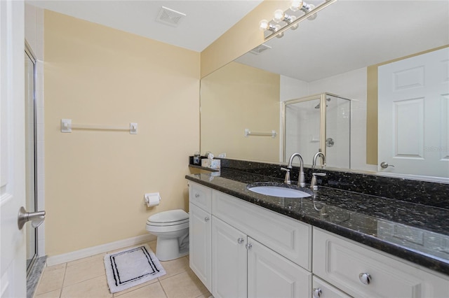 bathroom featuring a shower with door, vanity, toilet, and tile patterned floors