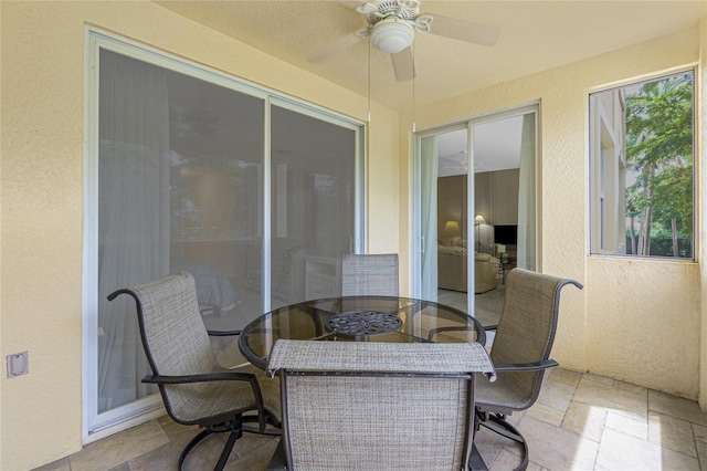 sunroom / solarium with a ceiling fan